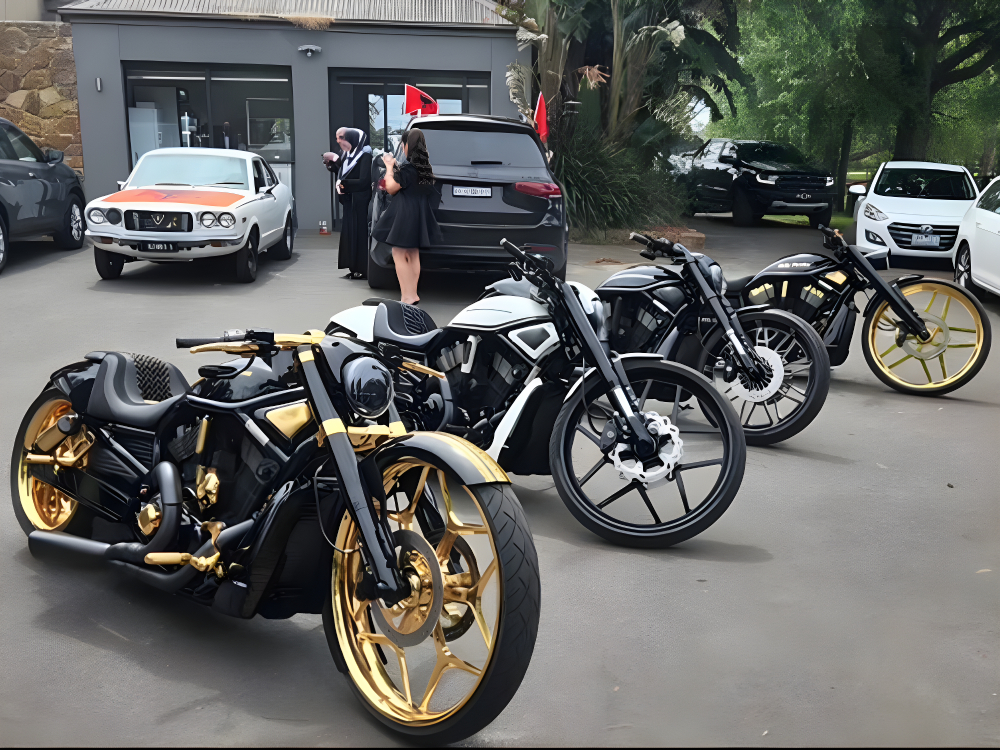 Black Harleys with gold and white trim lined up outside a building, guests nearby