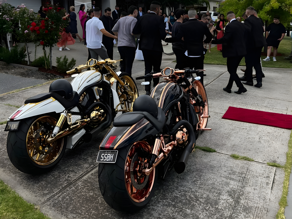 White and black Harleys with gold and copper wheels beside a red carpet