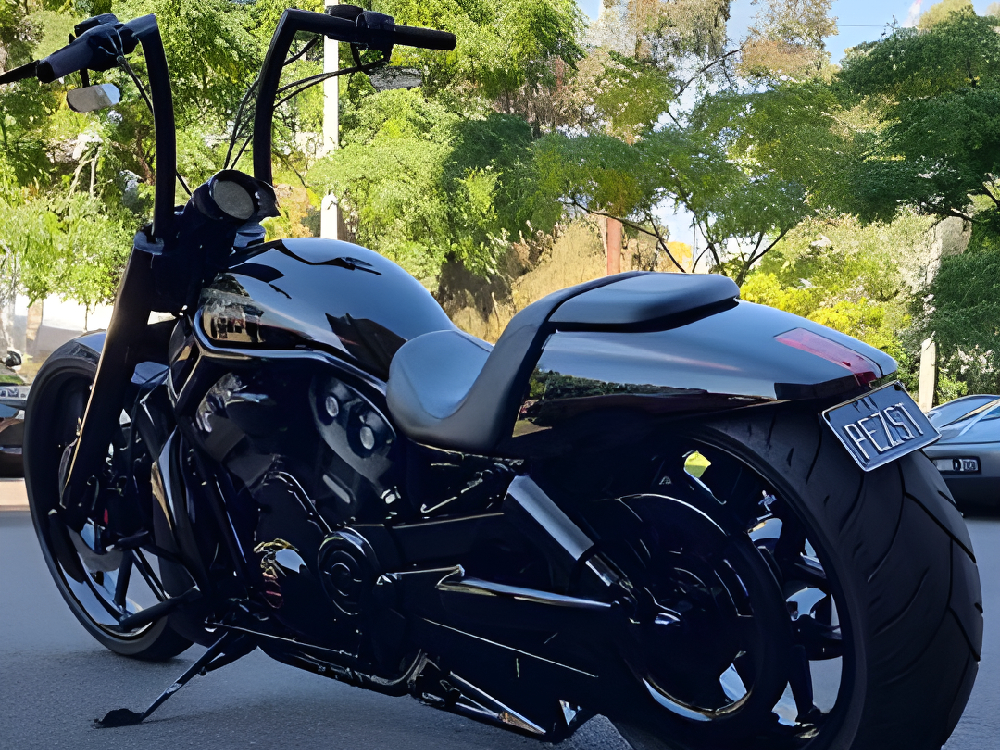 Close view of a glossy black Harley with tall handlebars